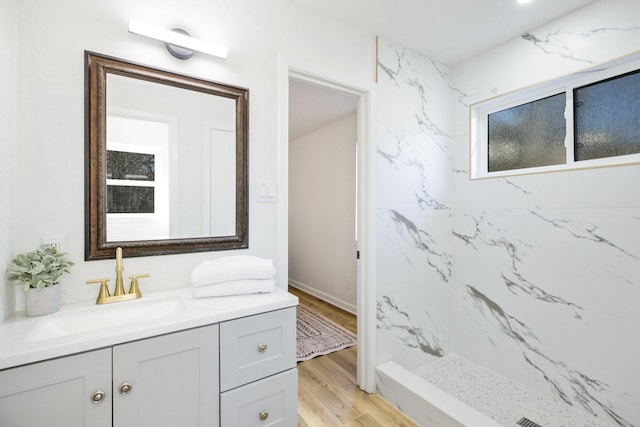 bathroom featuring walk in shower, wood finished floors, and vanity