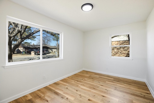 unfurnished room featuring baseboards and light wood finished floors