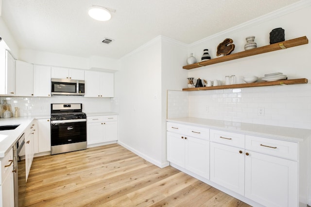 kitchen featuring white cabinets, visible vents, appliances with stainless steel finishes, and light countertops