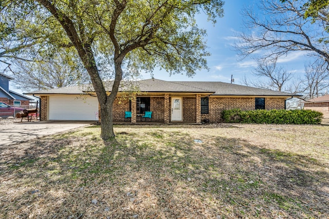 ranch-style home with a garage, a front yard, concrete driveway, and brick siding