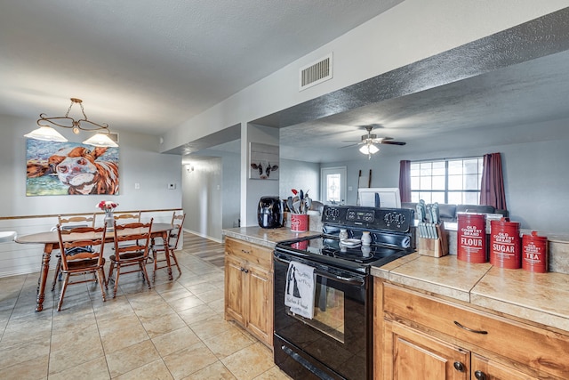 kitchen featuring pendant lighting, light tile patterned floors, visible vents, black electric range oven, and a textured ceiling