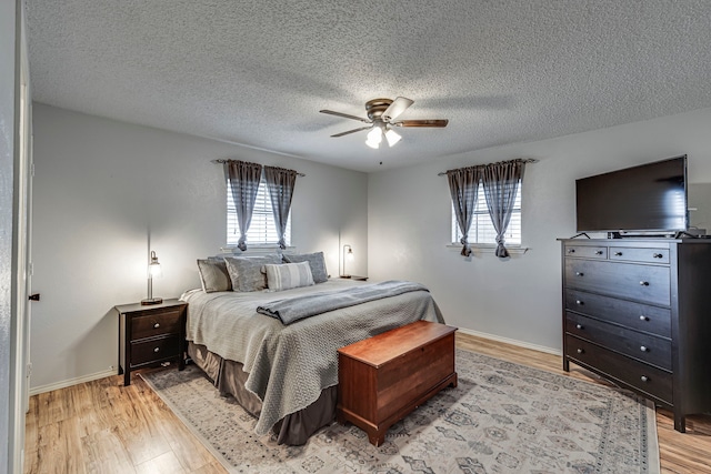 bedroom with light wood-type flooring, multiple windows, and baseboards