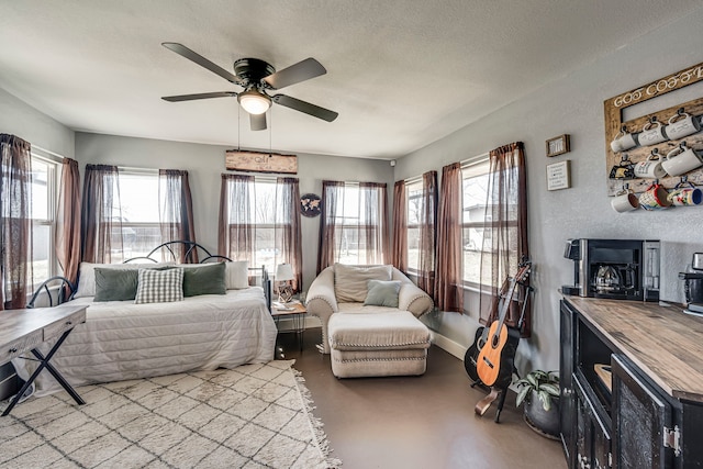 bedroom featuring multiple windows, a textured wall, a textured ceiling, and baseboards