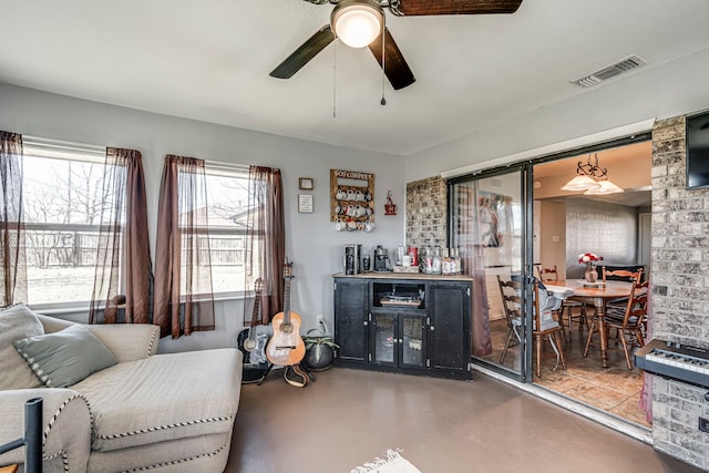 living room with finished concrete flooring, ceiling fan, and visible vents