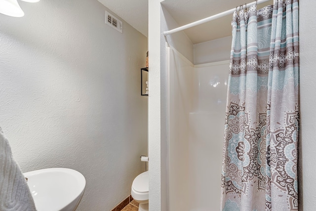 full bath with visible vents, a textured wall, toilet, a shower with shower curtain, and a sink