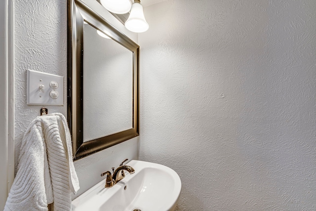 bathroom with a textured wall and a sink