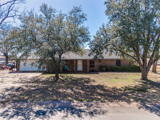 ranch-style house featuring driveway, an attached garage, and brick siding