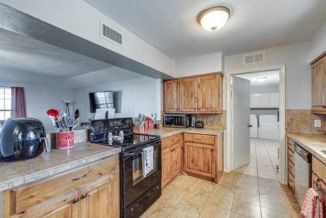 kitchen featuring visible vents, dishwasher, electric range, and washer and clothes dryer