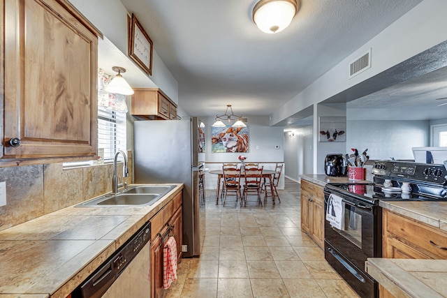 kitchen with decorative light fixtures, tile countertops, stainless steel appliances, visible vents, and a sink