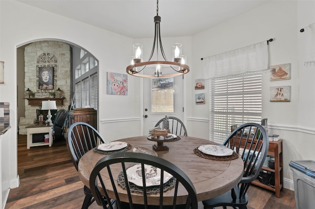 dining space with dark wood-type flooring and a notable chandelier