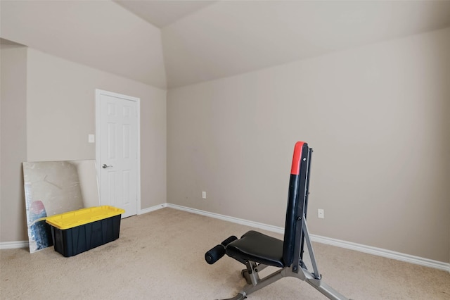 exercise room featuring carpet, vaulted ceiling, and baseboards