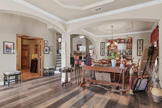 interior space featuring crown molding, a notable chandelier, visible vents, stairway, and wood finished floors