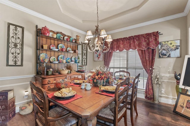 dining space featuring a tray ceiling, crown molding, a notable chandelier, dark wood-type flooring, and baseboards