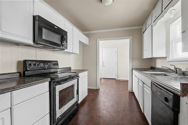 kitchen with black appliances, dark countertops, a sink, and white cabinetry