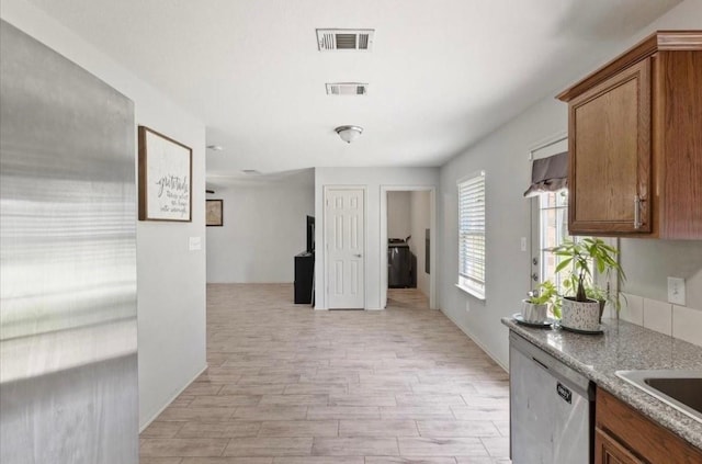 kitchen with visible vents, brown cabinets, and stainless steel dishwasher