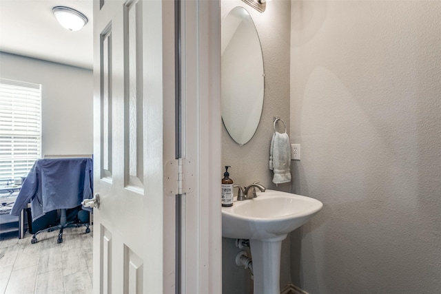 bathroom featuring a textured wall and a sink