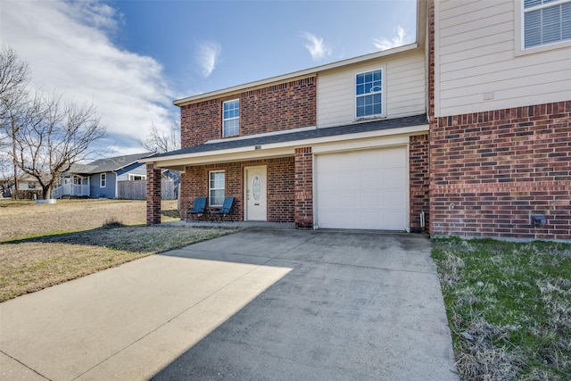 view of front of house featuring a garage, driveway, and brick siding