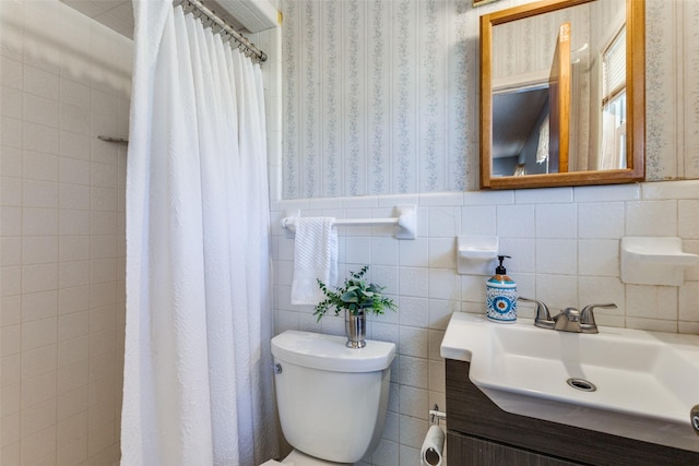 full bath featuring toilet, wallpapered walls, a shower with shower curtain, and wainscoting