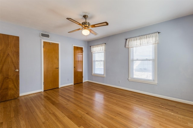 unfurnished bedroom featuring visible vents, ceiling fan, baseboards, and wood finished floors