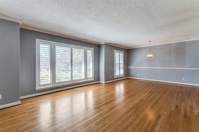 spare room with ornamental molding, baseboards, and wood finished floors