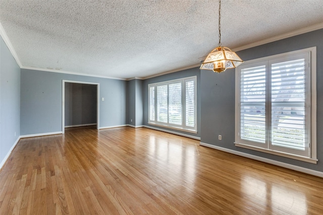 unfurnished room featuring baseboards, ornamental molding, and wood finished floors