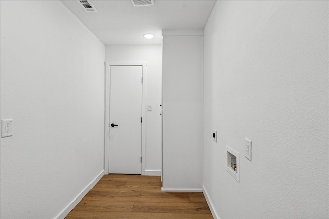 interior space with wood finished floors, visible vents, and baseboards