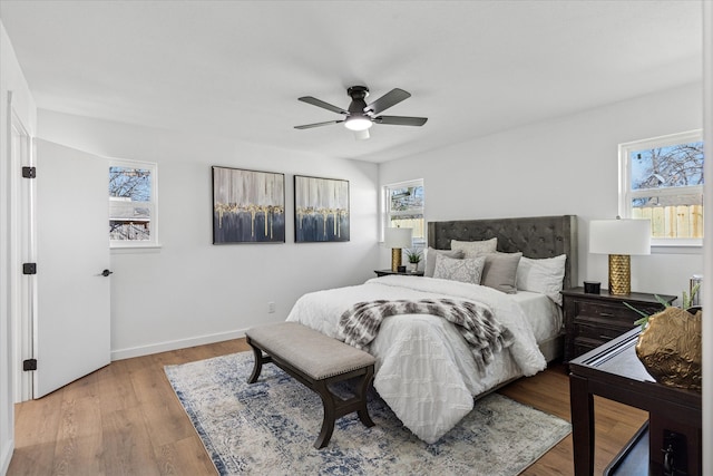 bedroom featuring a ceiling fan, baseboards, and wood finished floors