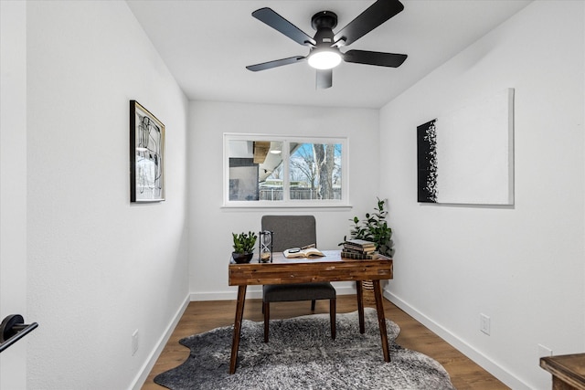 office space featuring a ceiling fan, baseboards, and wood finished floors