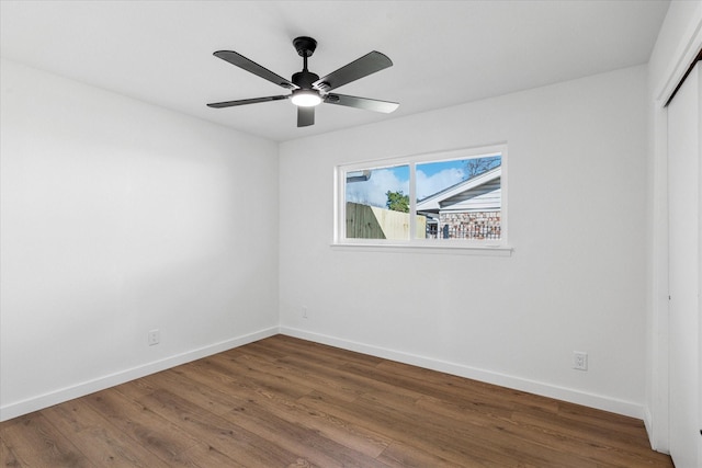 unfurnished bedroom featuring a closet, wood finished floors, a ceiling fan, and baseboards