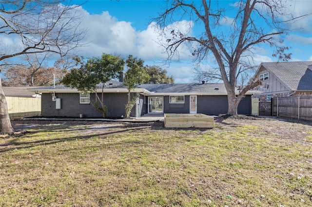 rear view of property with a patio, fence, a lawn, and brick siding