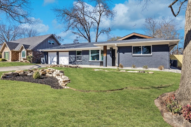 single story home with a garage, concrete driveway, central air condition unit, a front yard, and brick siding