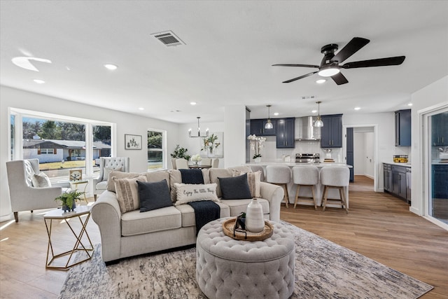 living area featuring light wood-style floors, recessed lighting, and visible vents