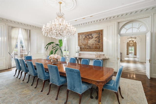 dining space featuring arched walkways, a decorative wall, ornamental molding, and an inviting chandelier