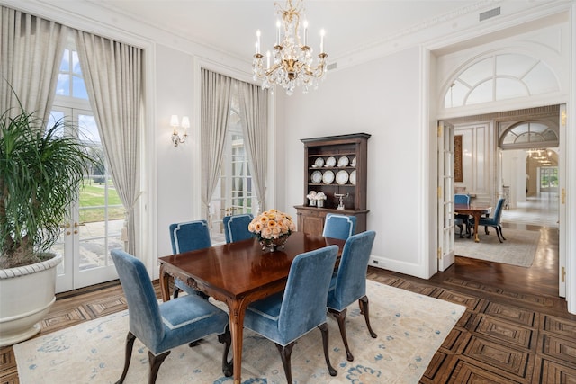 dining space with baseboards, visible vents, ornamental molding, and a notable chandelier