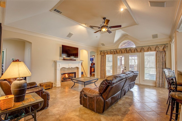 living area featuring lofted ceiling, visible vents, a fireplace, and arched walkways