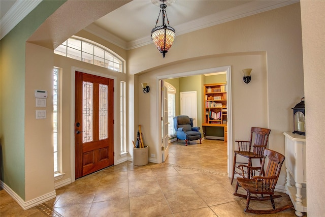 foyer entrance featuring a healthy amount of sunlight, baseboards, and ornamental molding