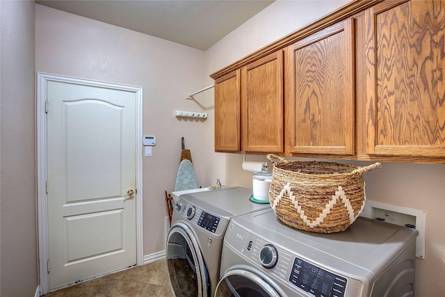 laundry room with separate washer and dryer, light tile patterned flooring, and cabinet space