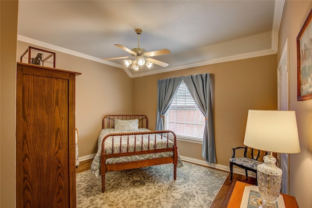 bedroom with ornamental molding, wood finished floors, a ceiling fan, and baseboards