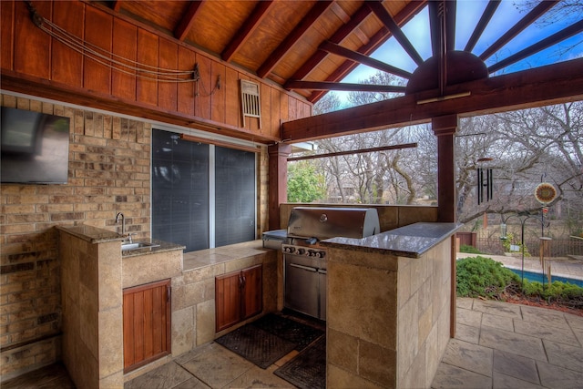 view of patio / terrace with grilling area, an outdoor kitchen, and a sink