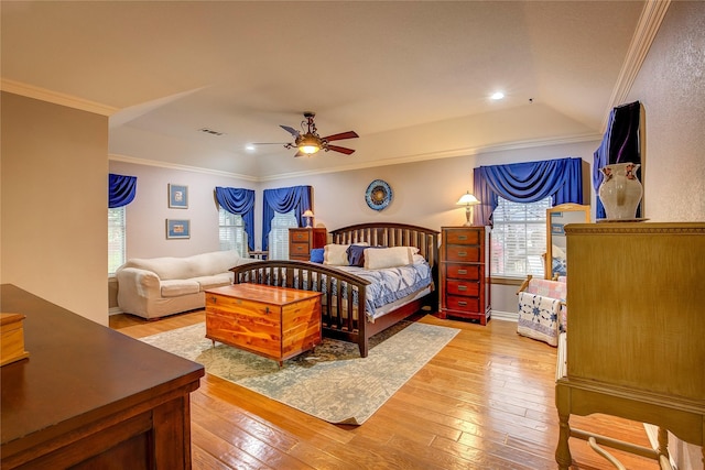 bedroom with ceiling fan, light wood-style floors, visible vents, and crown molding