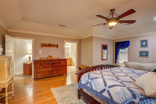 bedroom with ornamental molding, light wood finished floors, a raised ceiling, and visible vents