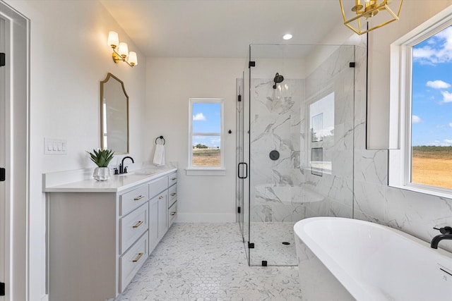 bathroom featuring a soaking tub, a marble finish shower, baseboards, and vanity