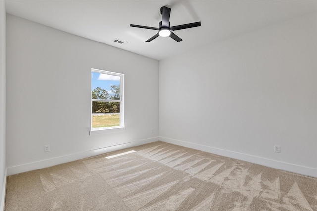 empty room featuring light colored carpet, visible vents, and baseboards