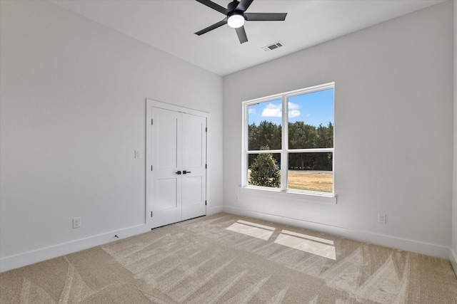 spare room with light carpet, baseboards, and visible vents