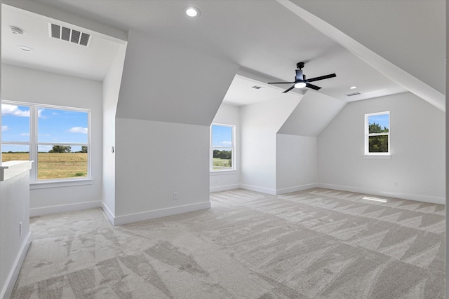 bonus room with a wealth of natural light, visible vents, light carpet, and baseboards