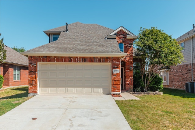 traditional-style home featuring central air condition unit, a garage, brick siding, a shingled roof, and a front yard