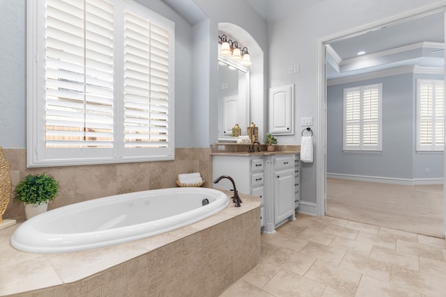 bathroom with ornamental molding, vanity, baseboards, and a bath