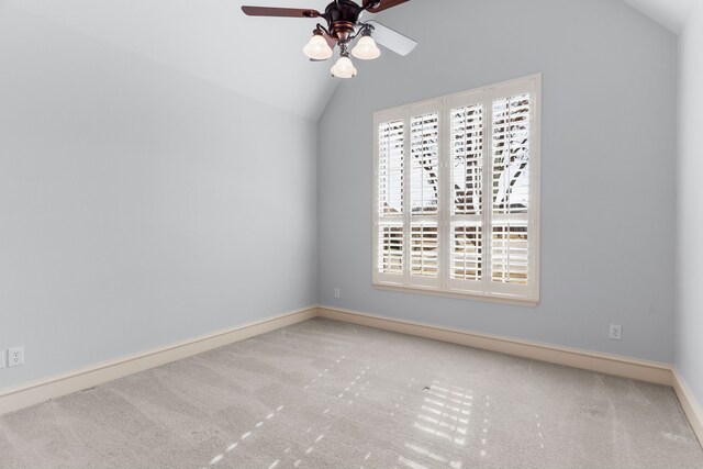 carpeted spare room with a ceiling fan, lofted ceiling, and baseboards