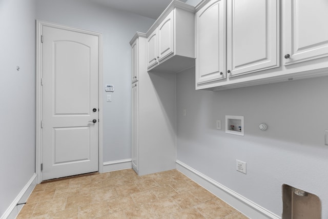 laundry area with washer hookup, cabinet space, stone finish floor, gas dryer hookup, and baseboards