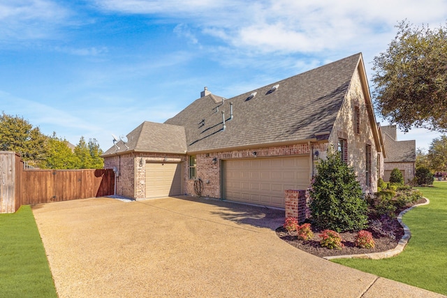 view of front facade featuring brick siding, roof with shingles, an attached garage, fence, and a front yard